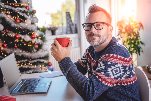 Man sitting in home with coffee on laptop